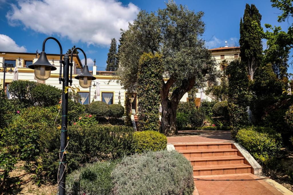 une maison avec un arbre et des escaliers devant dans l'établissement L'Antico Uliveto, à Porto Potenza Picena