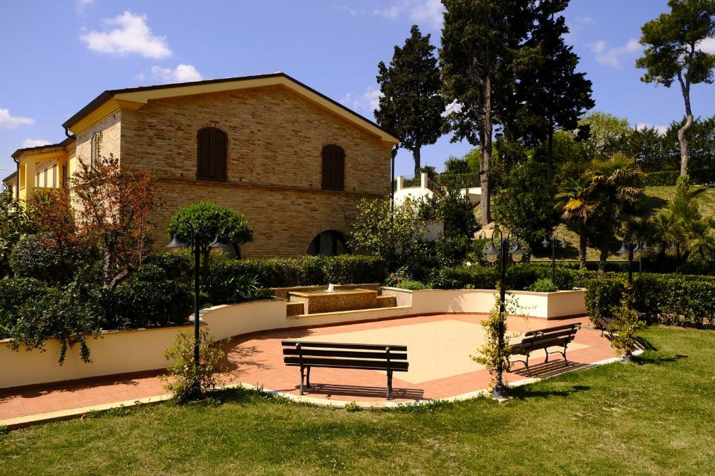 2 bancs dans un parc devant un bâtiment dans l'établissement L'Antico Uliveto, à Porto Potenza Picena 34 autres photos