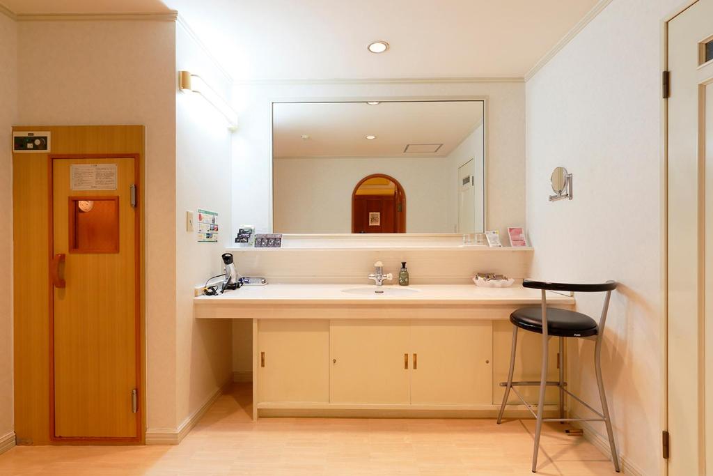 une salle de bain avec un lavabo et un miroir dans l'établissement HOTEL555 伊豆長岡, à Izunokuni