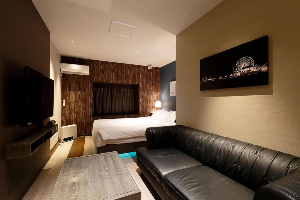 une chambre d'hôtel avec un canapé et un lit dans l'établissement 555 MOTEL GOTEMBA, à Gotemba