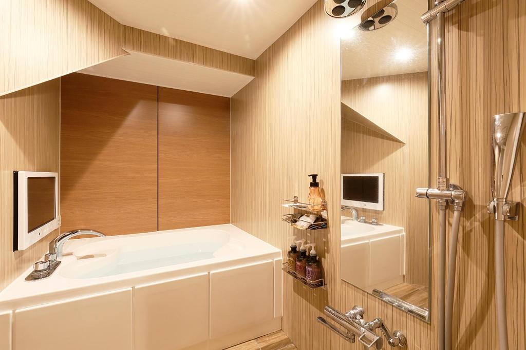une salle de bain avec une baignoire et un lavabo dans l'établissement 555 MOTEL GOTEMBA, à Gotemba