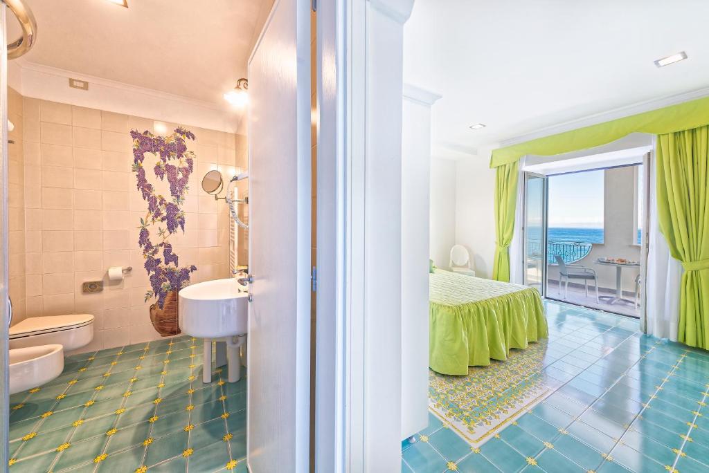 une salle de bain avec un lit et une salle de bain avec une fenêtre dans l'établissement Hotel La Madonnina, à Ischia