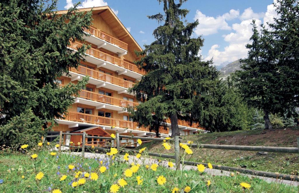 un bâtiment au milieu d'un champ de fleurs dans l'établissement Résidence partenaire Le Golf, à Méribel 37 autres photos