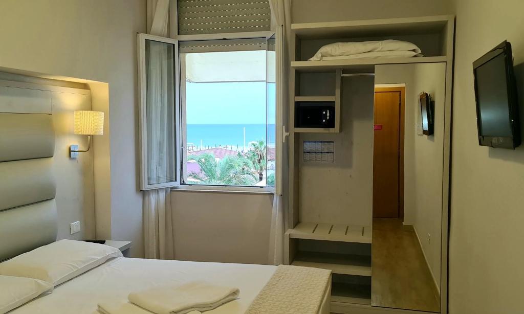 une petite pièce avec un lit et une fenêtre dans l'établissement Hotel Biagi & Residence, à Lido di Camaiore