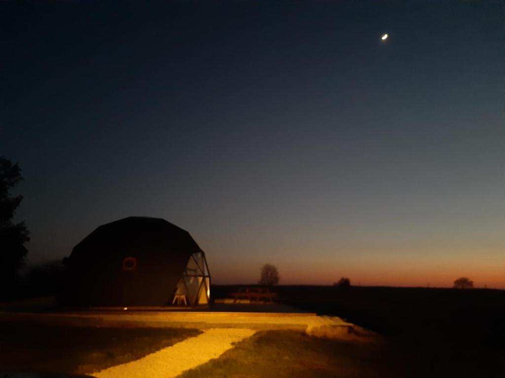 une tente en forme de dôme au milieu d'un champ la nuit dans l'établissement Dôme La vue étoilée, à Poinson-lès-Fays