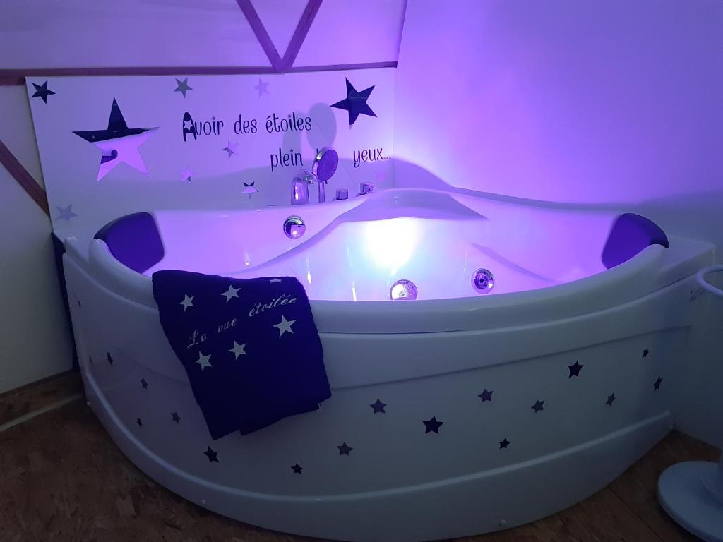 La salle de bains est pourvue d'une baignoire avec des étoiles sur le mur. dans l'établissement Dôme La vue étoilée, à Poinson-lès-Fays