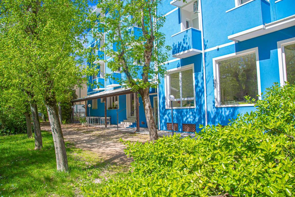 un bâtiment bleu avec des arbres devant lui dans l'établissement Hotel Rio Beach & Breakfast, à Cesenatico