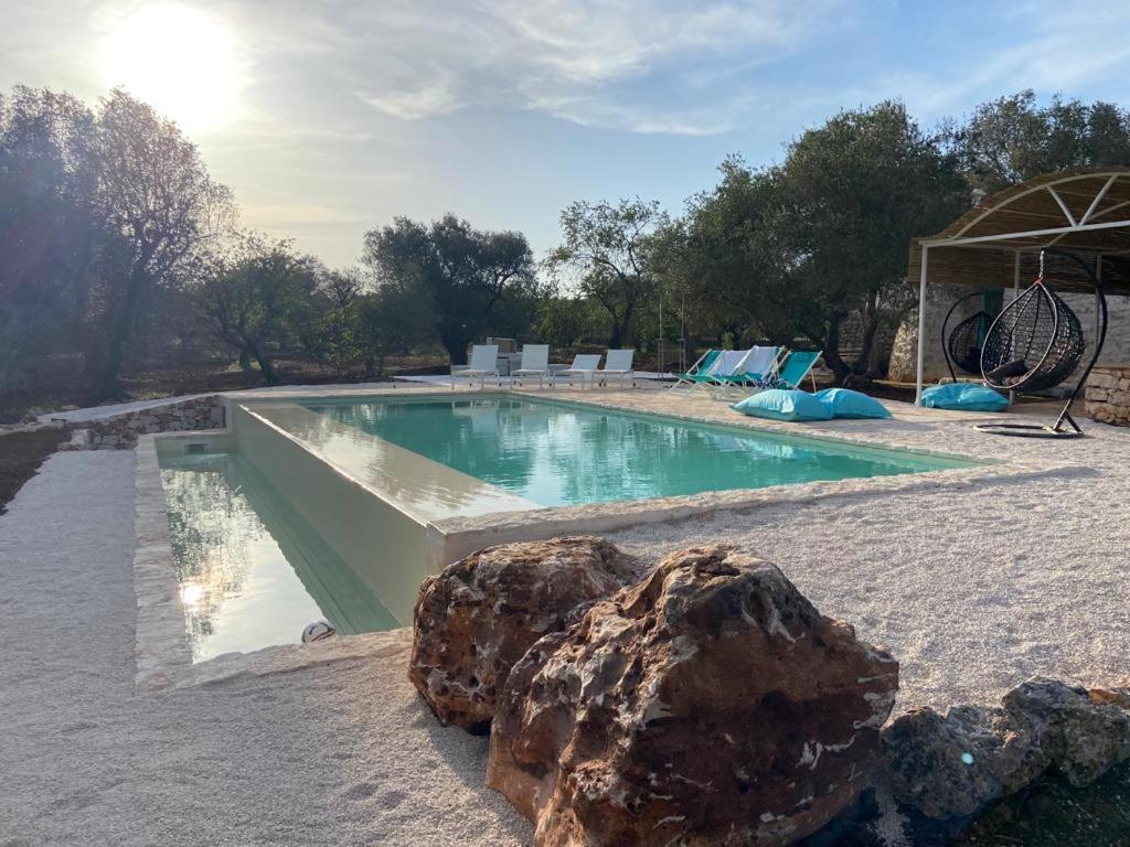 - une piscine avec un rocher en face dans l'établissement Trulli di Charme Eutuxia, à Villa Castelli 51 autres photos