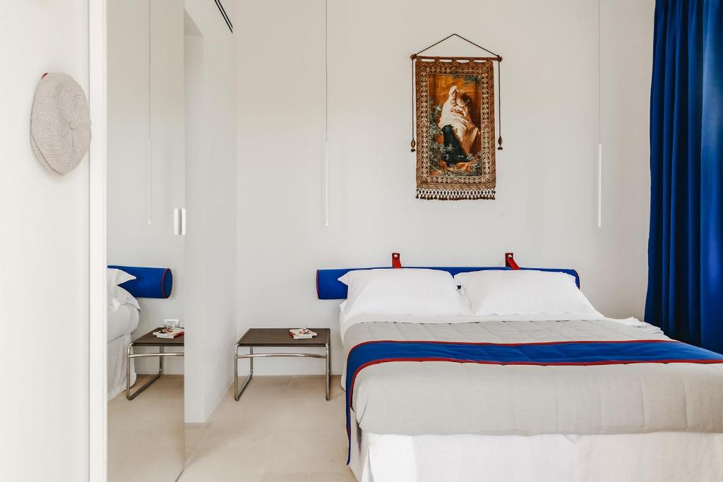 Cette chambre blanche dispose d'un lit et d'une photo murale. dans l'établissement Kubo Sea Views Luxury Escape, à Lecce