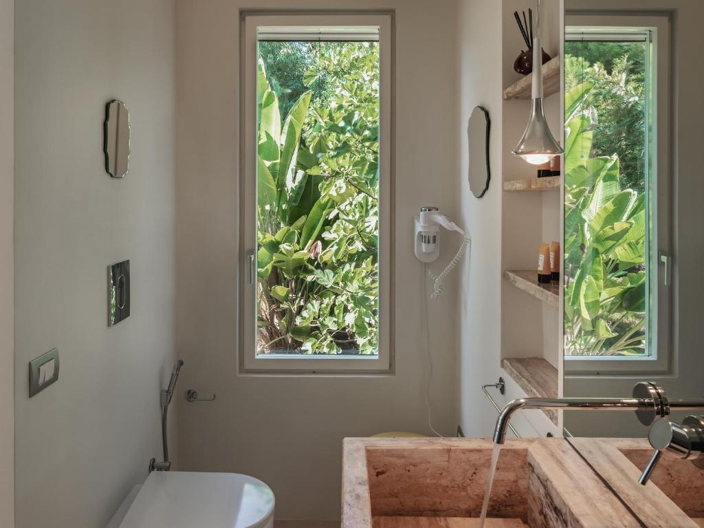 La salle de bains est pourvue d'une fenêtre, d'une baignoire et d'un lavabo. dans l'établissement Kubo Sea Views Luxury Escape, à Lecce 87 autres photos