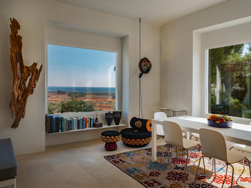 une salle à manger avec une table et des chaises et une grande fenêtre dans l'établissement Kubo Sea Views Luxury Escape, à Lecce