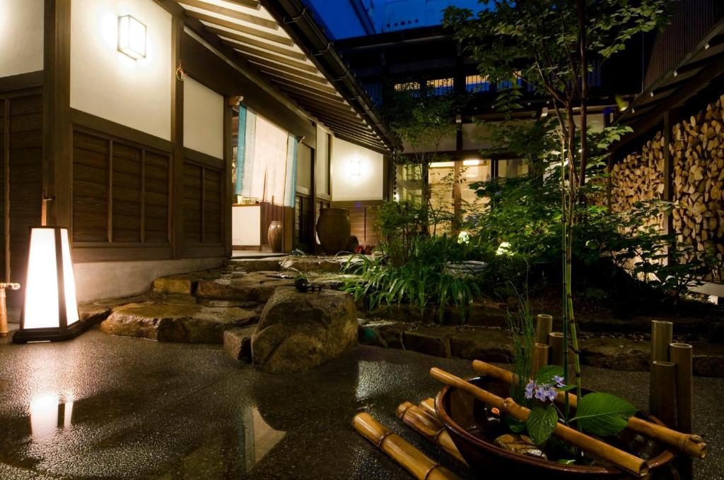 - un bâtiment avec un jardin agrémenté de rochers et d'une table dans l'établissement Oyado Koto No Yume, à Takayama
