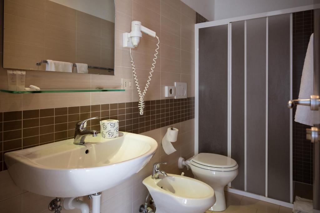 une salle de bain avec un lavabo et des toilettes dans l'établissement Hotel Elios Tao, à Taormine 277 autres photos