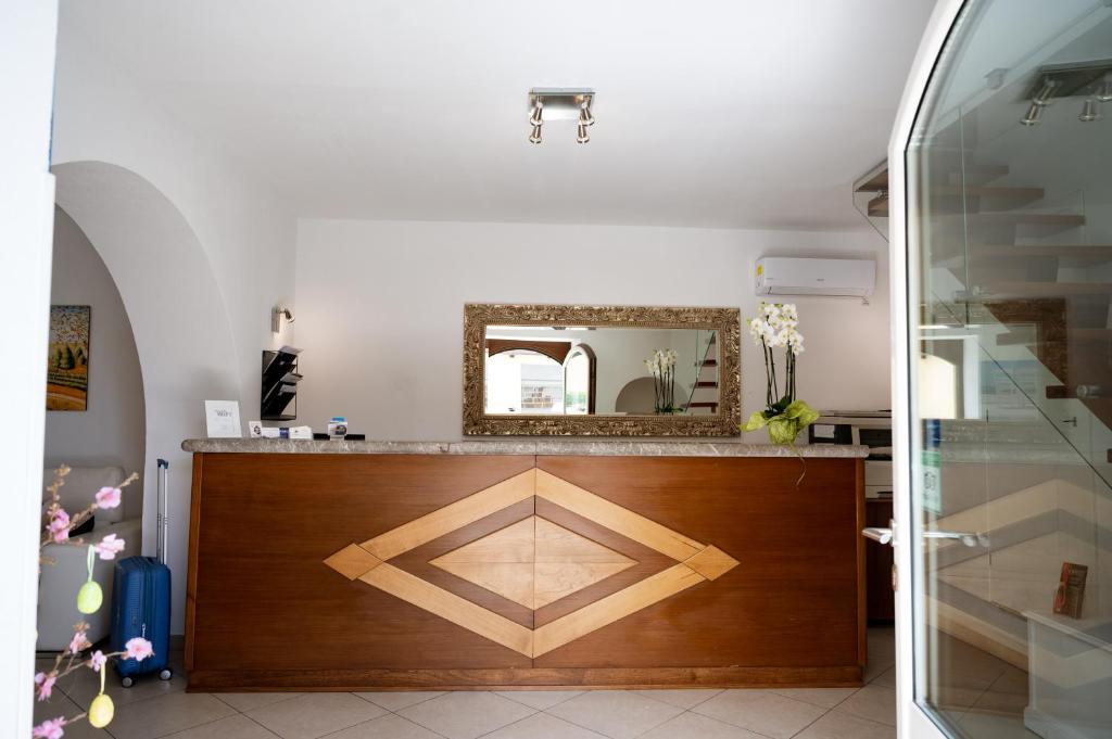 une salle de bain avec un miroir et un comptoir en bois dans l'établissement Hotel Elios Tao, à Taormine