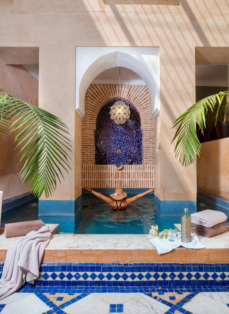 - une piscine dans un complexe avec une fontaine dans l'établissement Riad Ines Home, à Marrakech