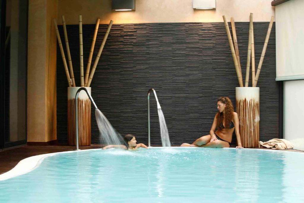 une femme et un enfant dans une piscine dans l'établissement Residence Eden & Spa, à Gabicce Mare