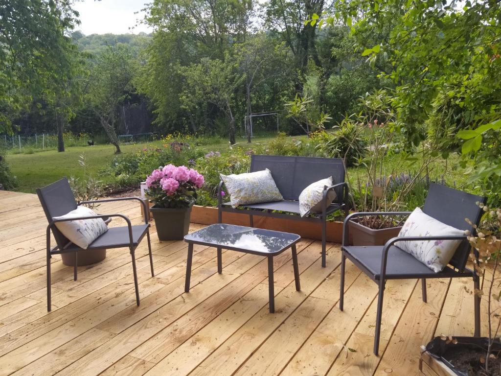 un patio avec des chaises et un canapé sur une terrasse en bois dans l'établissement Yourte Bourgogne, à Corvol-dʼEmbernard