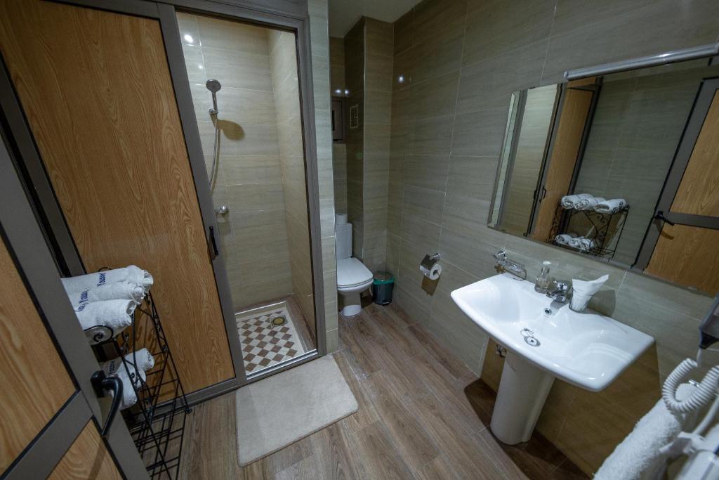 une salle de bain avec un lavabo, des toilettes et un miroir dans l'établissement Ksar Ben Youssef, à Ouarzazate 37 autres photos