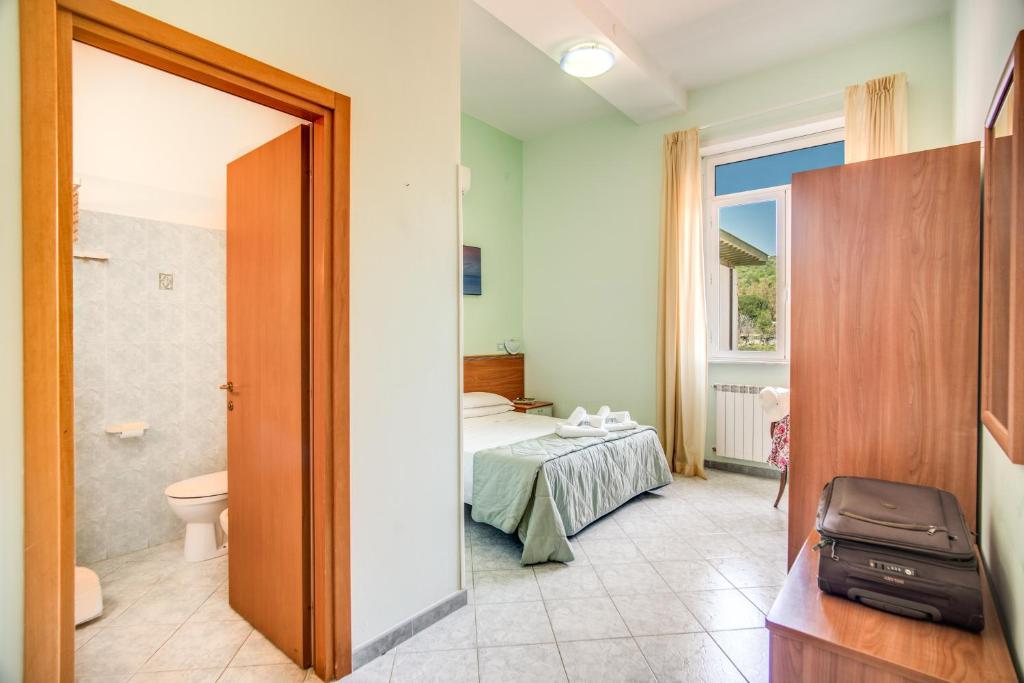 une chambre avec un lit et une salle de bain dans l'établissement Villa MG Hotel, à Santa Marinella