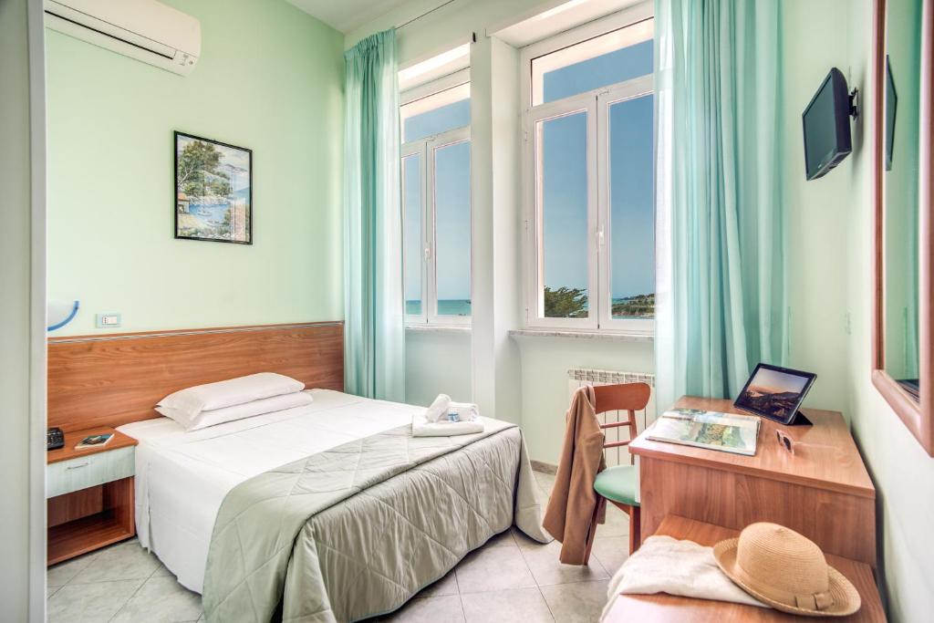 une chambre d'hôtel avec un lit, un bureau et une fenêtre dans l'établissement Villa MG Hotel, à Santa Marinella 66 autres photos