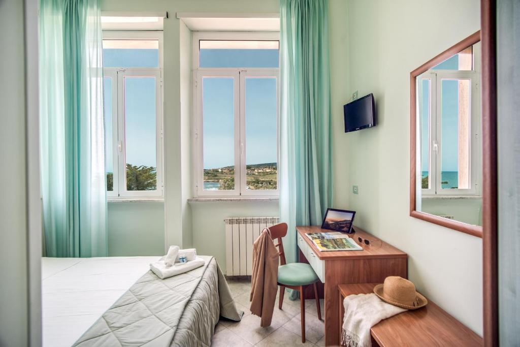 - une chambre avec un bureau et un lit dans l'établissement Villa MG Hotel, à Santa Marinella
