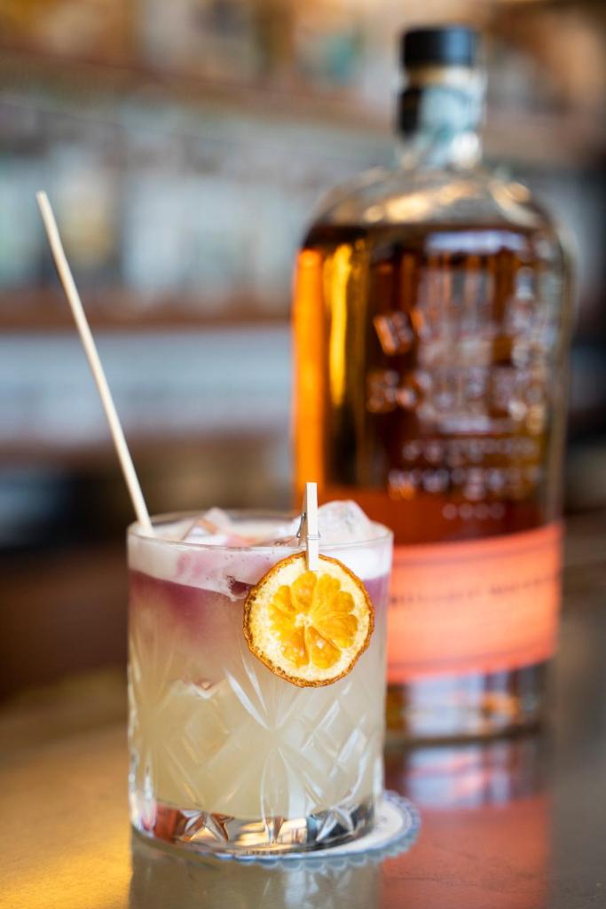 une boisson avec une tranche d'orange devant une bouteille dans l'établissement Albergo Celeste, à Sestri Levante 41 autres photos