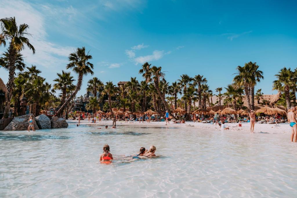 un groupe de personnes dans l'eau sur une plage dans l'établissement Hotel Verdi, à Lido di Jesolo