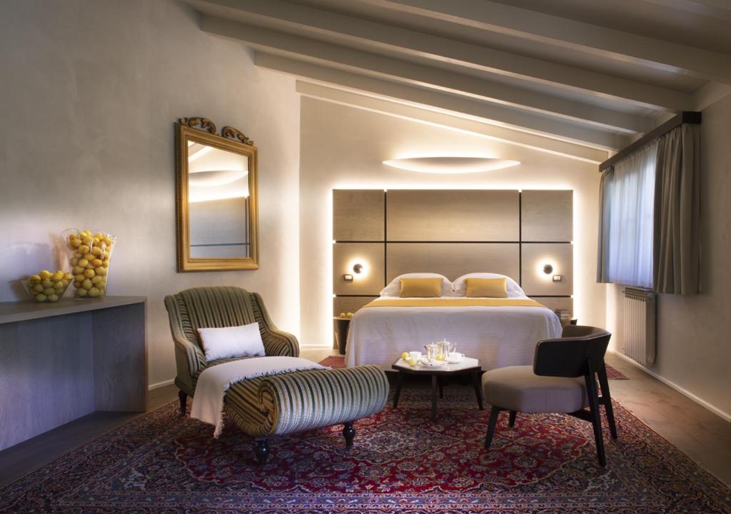 une chambre avec un lit, deux chaises et une table dans l'établissement Hotel Villa Giulia, à Gargnano