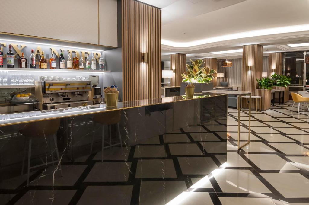 un hall d'entrée avec un bar et un restaurant dans l'établissement Hotel Alexander, à Cattolica