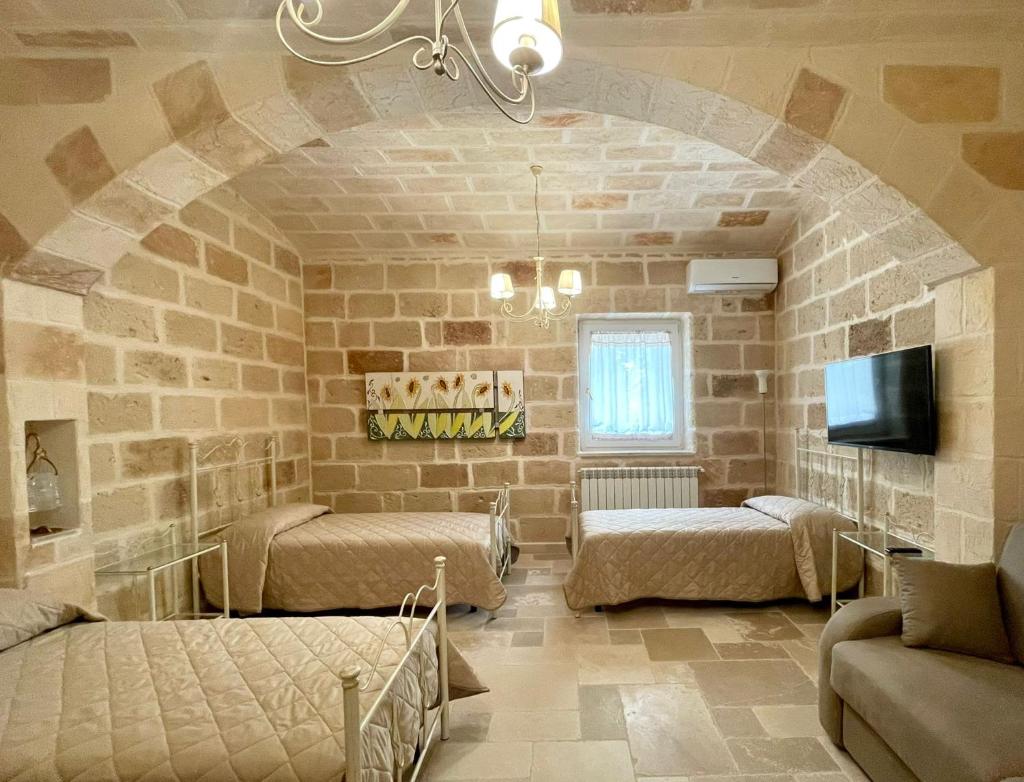 - une chambre avec 2 lits dans une pièce dotée d'un mur en pierre dans l'établissement Overseas Pool Villa, à Monopoli