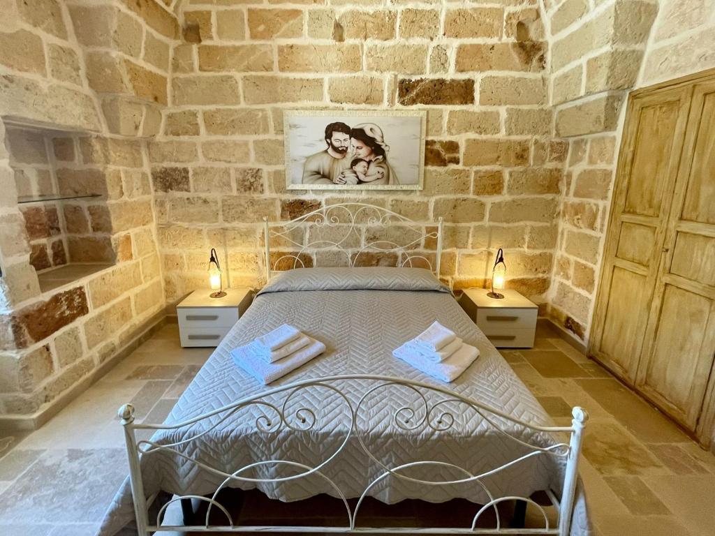 une chambre avec un lit dans un mur de pierre dans l'établissement Overseas Pool Villa, à Monopoli