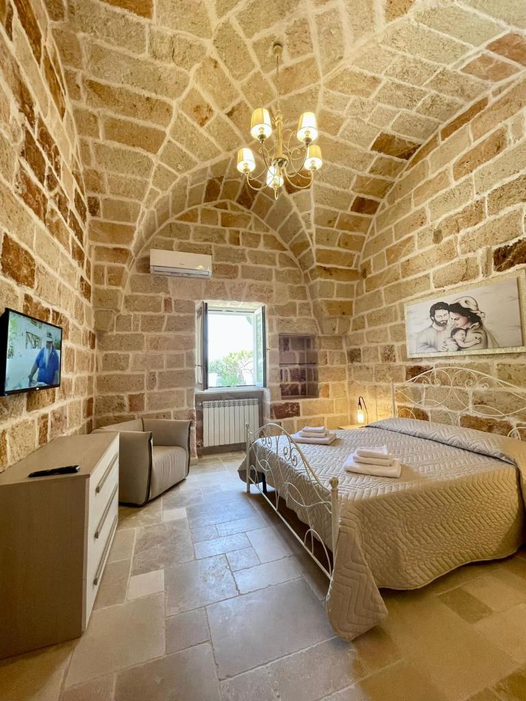 une chambre avec un grand lit dans un mur de pierre dans l'établissement Overseas Pool Villa, à Monopoli