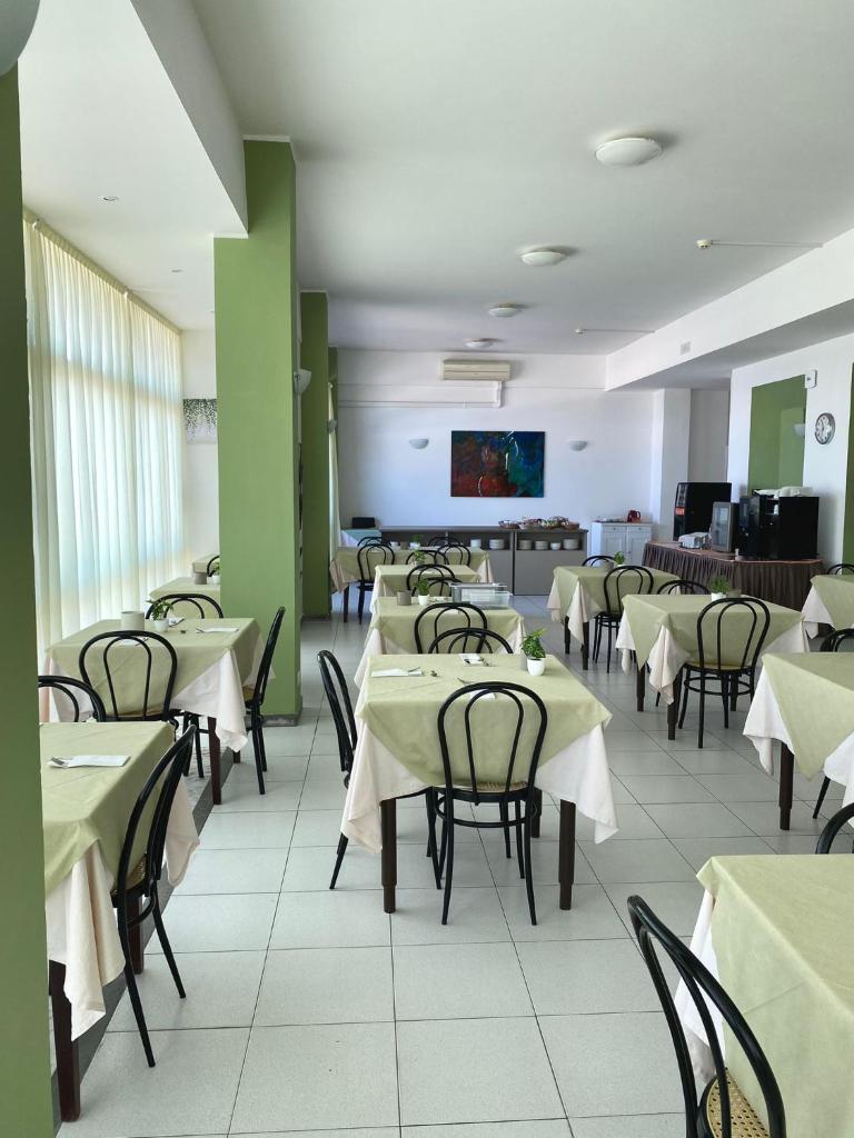 une salle à manger avec tables et chaises et une télévision dans l'établissement HOTEL FLYING, à Pesaro