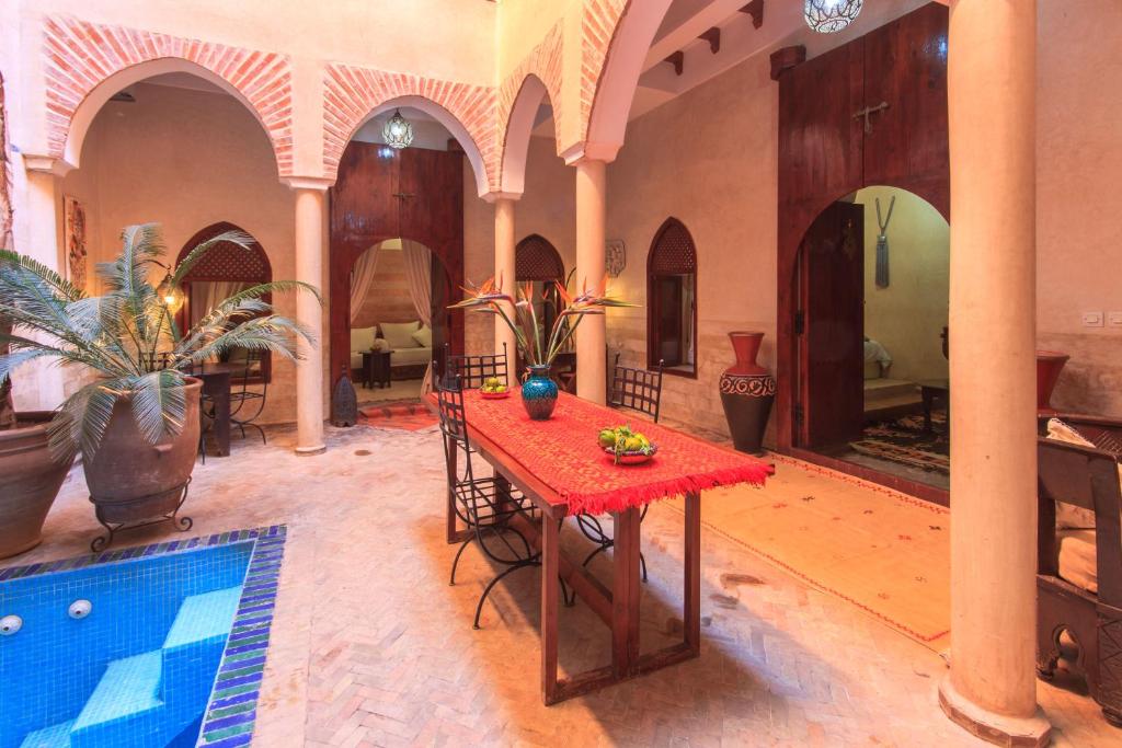 une chambre avec une table et une piscine dans l'établissement Riad Zen House, à Marrakech