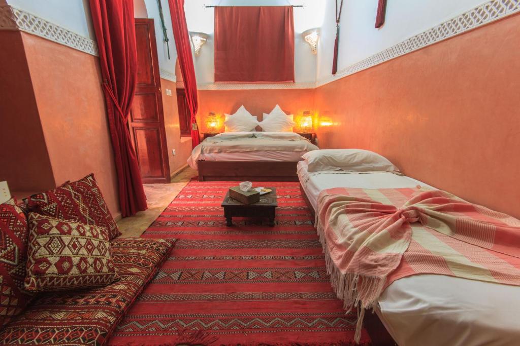 une chambre d'hôtel avec deux lits et un canapé dans l'établissement Riad Zen House, à Marrakech