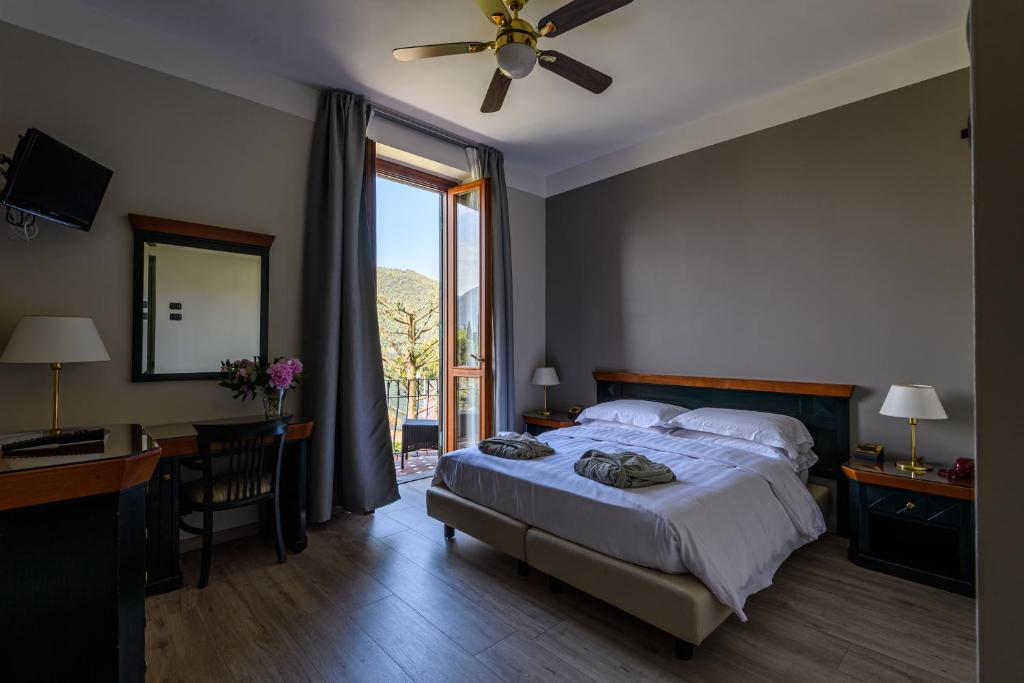 une chambre avec un lit, un bureau et une fenêtre dans l'établissement Villa Kinzica, à Sale Marasino