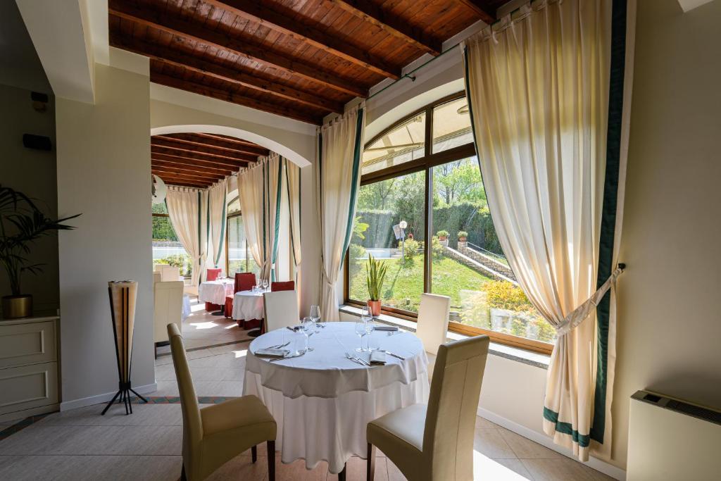 une salle à manger avec une table et des chaises et une grande fenêtre dans l'établissement Villa Kinzica, à Sale Marasino