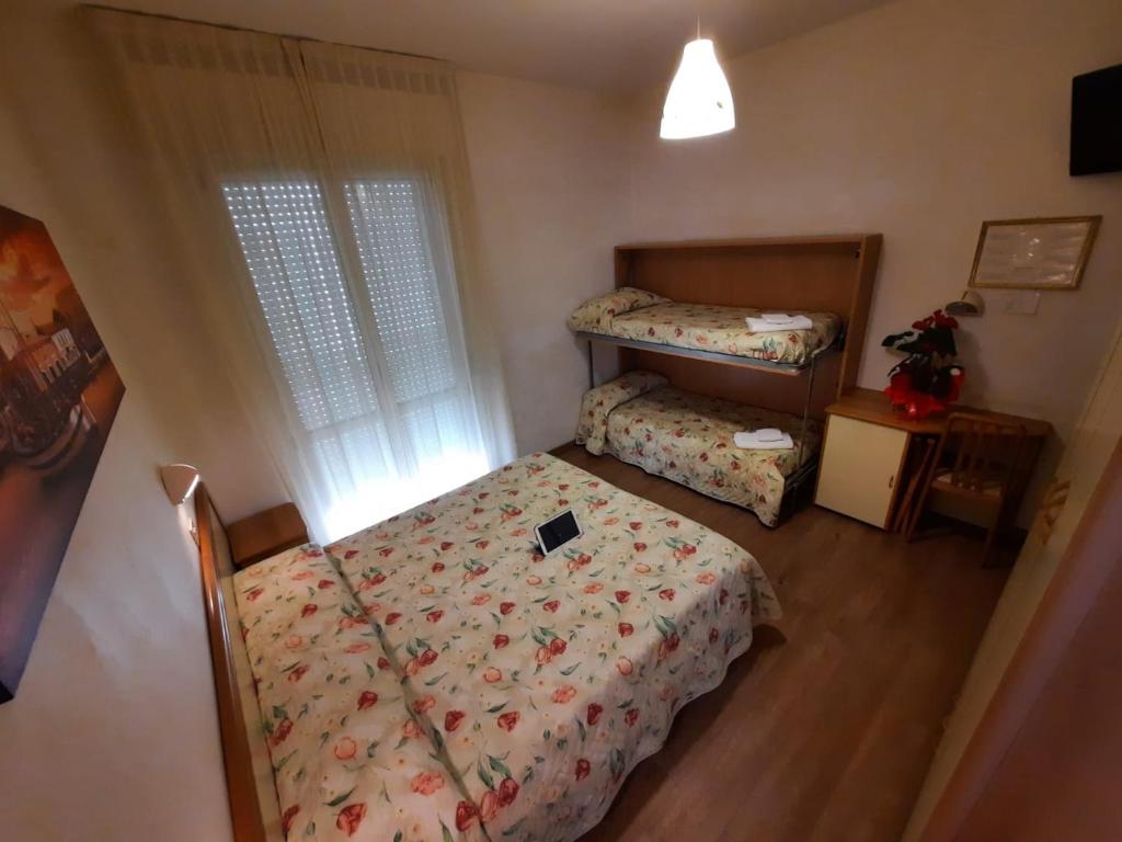 une petite chambre avec deux lits et une fenêtre dans l'établissement Hotel Losanna Cervia, à Cervia