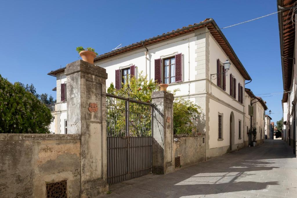 Maison blanche avec portail dans une rue dans l'établissement Villa Cicogna, Private villa with exclusive use pool, à Terranuova Bracciolini