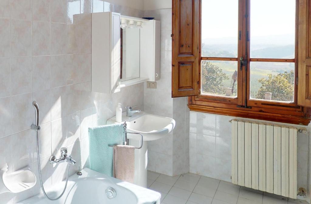 une salle de bain blanche avec un lavabo et un miroir dans l'établissement Villa Cicogna, Private villa with exclusive use pool, à Terranuova Bracciolini