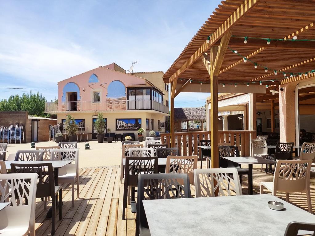 un restaurant avec des tables et des chaises sur une terrasse en bois dans l'établissement MOBIL HOME LE BIENVENUE 3 CH VALRAS PLAGE, à Valras-Plage
