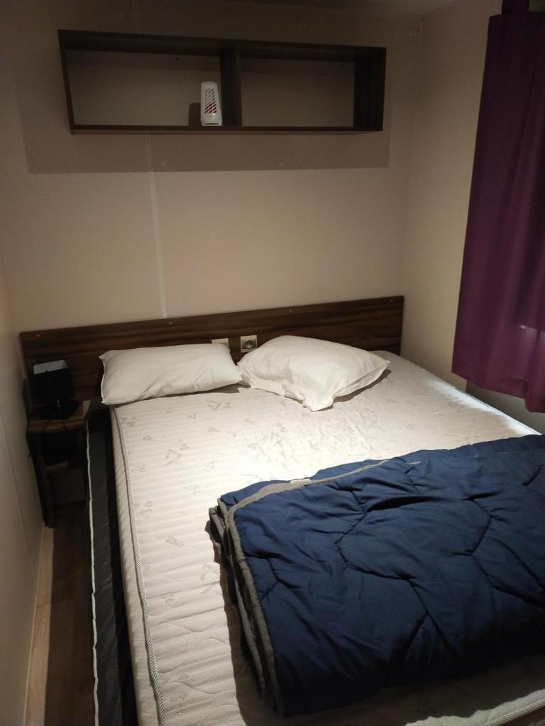 - un lit avec 2 oreillers dans l'établissement MOBIL HOME LE BIENVENUE 3 CH VALRAS PLAGE, à Valras-Plage