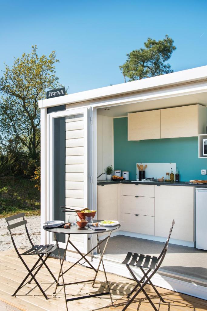 un patio avec une table et deux chaises ainsi qu'une cuisine dans l'établissement Camping VITAMIN DIEPPE, à Saint-Aubin-sur-Scie