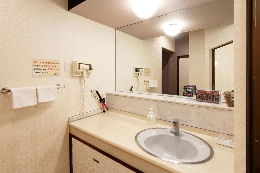 une salle de bain avec un lavabo et un grand miroir dans l'établissement 隠家(ajito) HOTEL555 御殿場2, à Gotemba