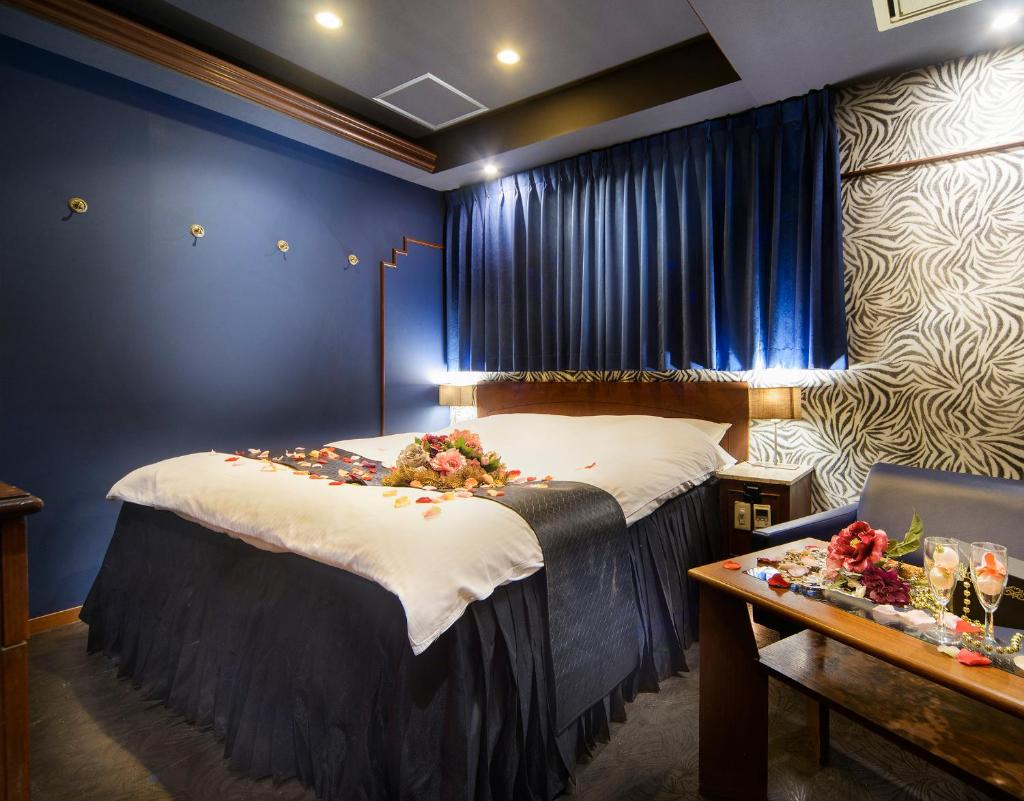 une chambre avec un lit avec des fleurs dessus dans l'établissement ホテル リトルチャペルクリスマス 梅田, à Osaka