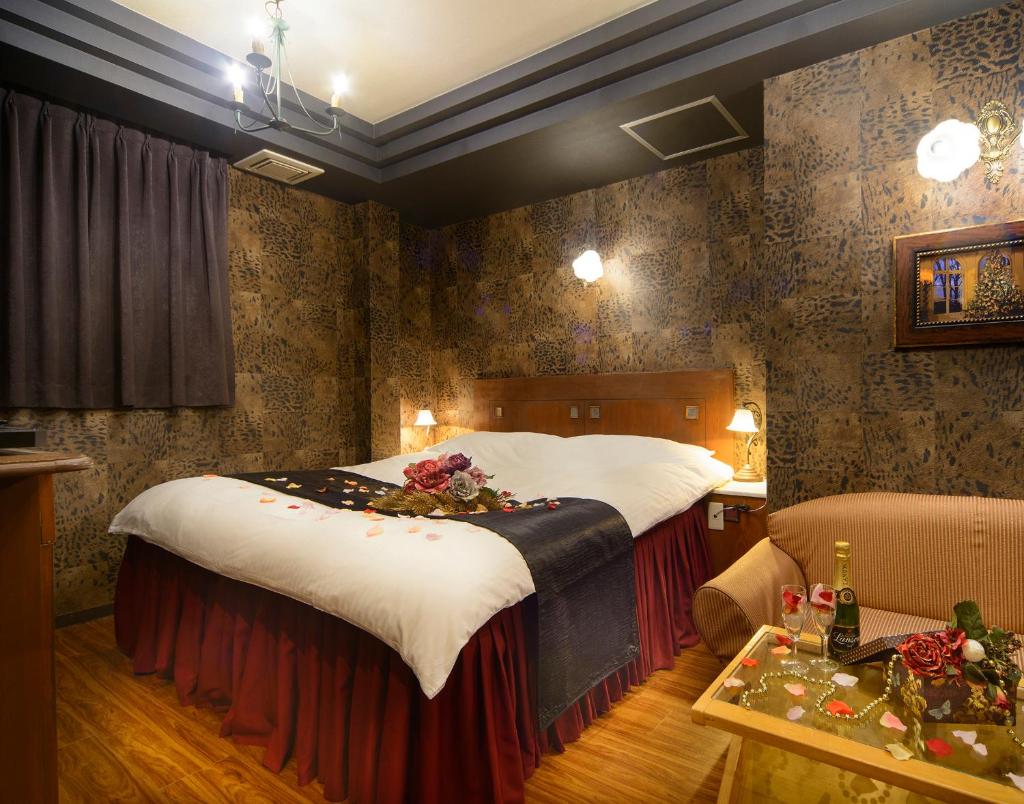 une chambre d'hôtel avec un grand lit et un canapé dans l'établissement ホテル リトルチャペルクリスマス 梅田, à Osaka