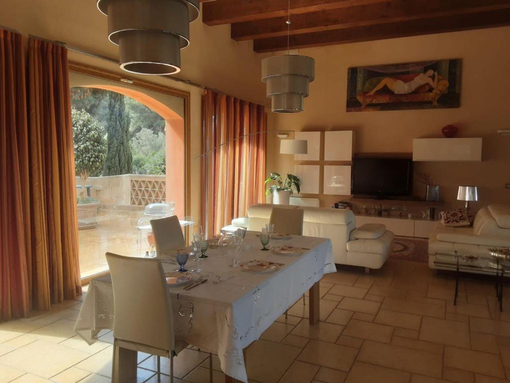 un salon avec une table et une grande fenêtre dans l'établissement Villa Dammusello, à Marsala