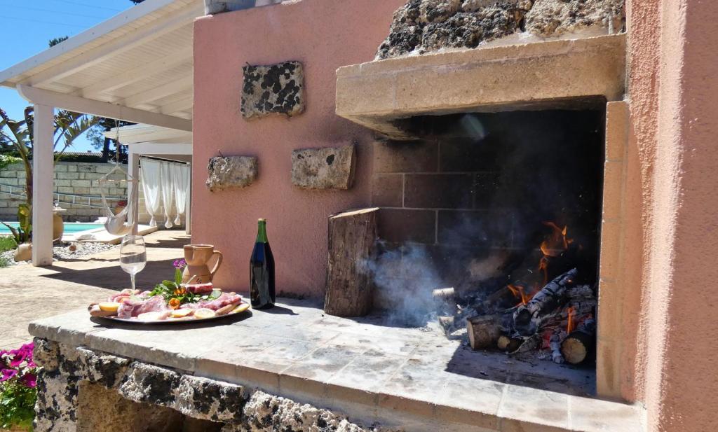 un foyer avec une assiette de nourriture et une pizza dans l'établissement La Vigna Salentina - Con Giardino e Piscina Privata, à Alessano
