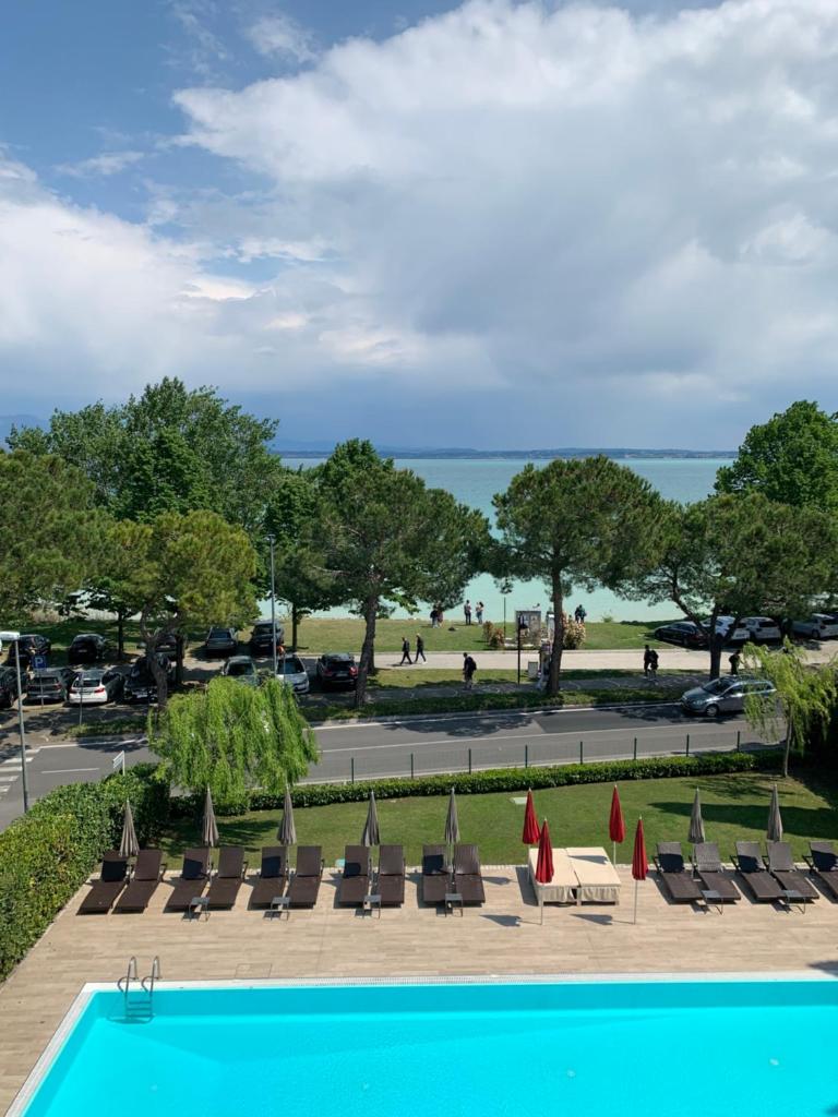 une piscine avec des chaises et une vue sur l'océan dans l'établissement Residence Alexandra Stay, à Sirmione