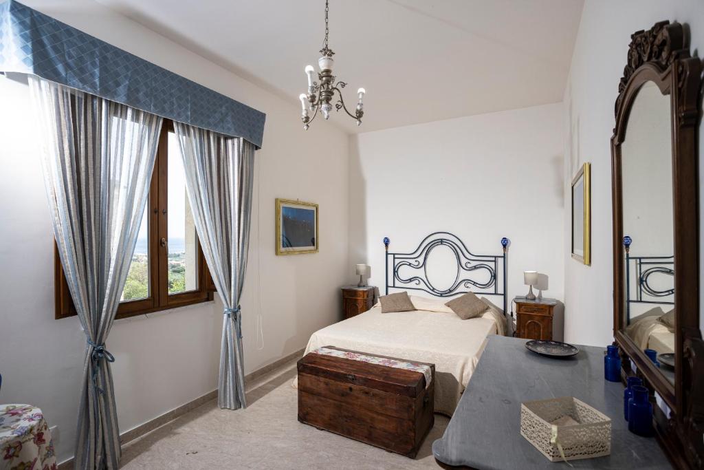 une chambre avec un lit, une table et une fenêtre dans l'établissement Villa Fontana, à Valderice